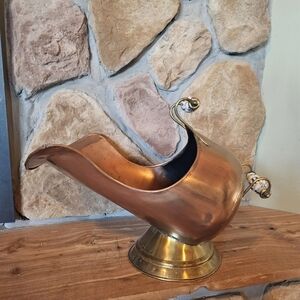 vintage copper and brass coal scuttle, used for holding coal next to a fireplace